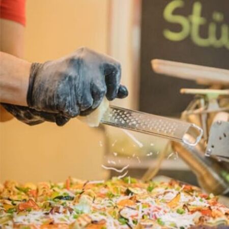 Pizzabäcker belegt Pizza